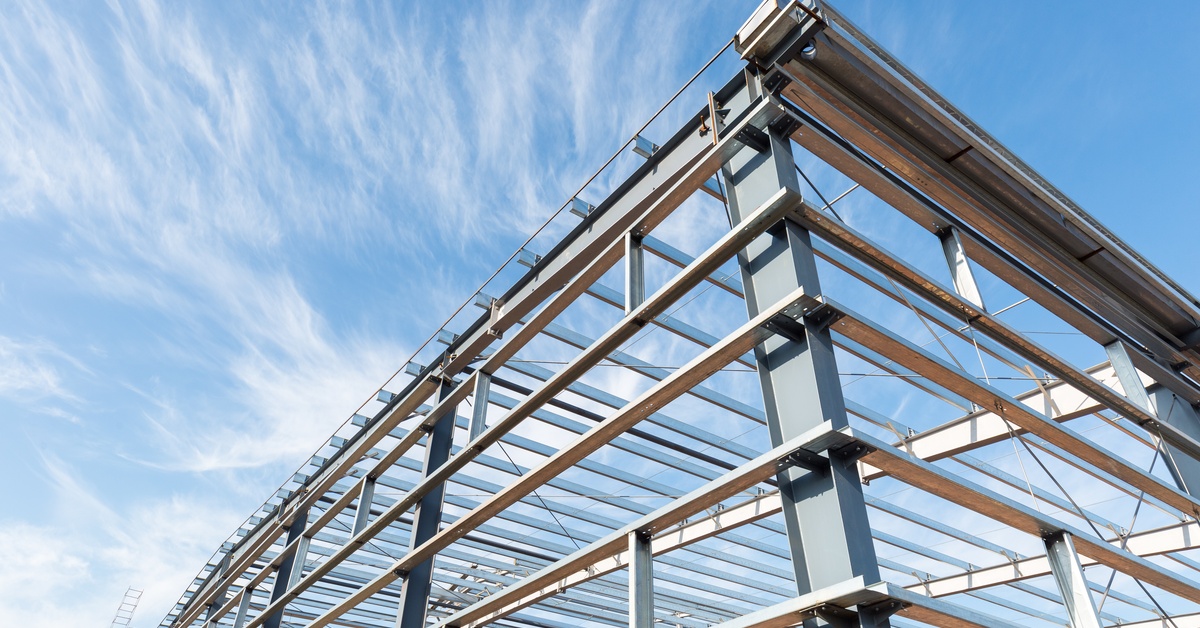 A metal structure that is still under construction. The sky is visible and there are wispy clouds.