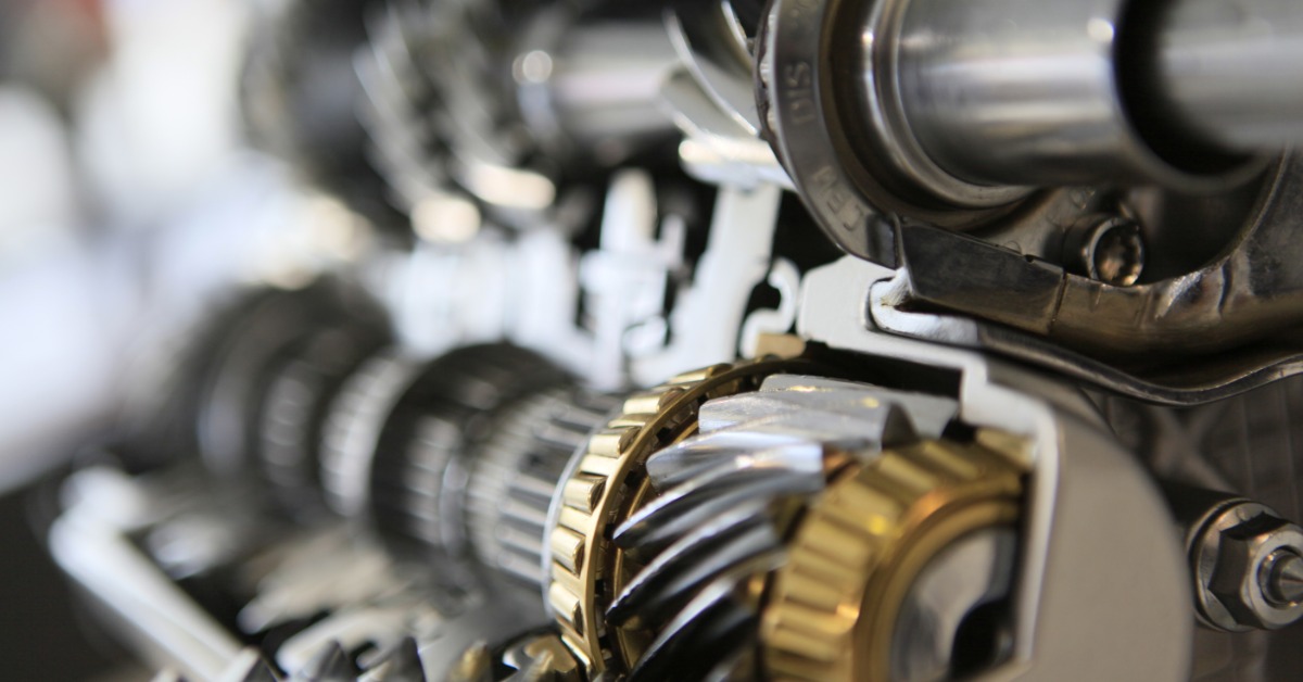 A piece of machinery featuring many metal gears in its construction. Some of the gears are stainless steel while others are brass.