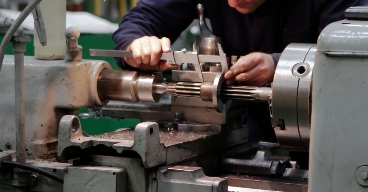 A close-up of several gears all interlocked. They are situated in several rows and are made of metal.